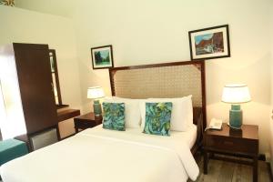 Cette chambre d'hôtel comprend un lit avec deux lampes et un téléphone. dans l'établissement Weekends El Nido Beach Resort, à El Nido