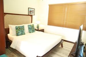 a bedroom with a white bed and a window at Weekends El Nido Beach Resort in El Nido