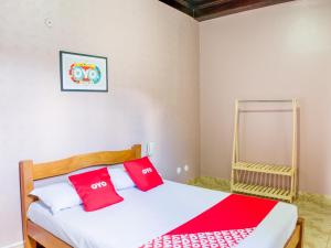 a bedroom with a bed with red pillows on it at OYO Hotel Lindoia, Petropolis in Petrópolis