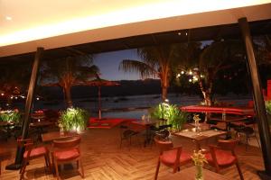 a restaurant with tables and chairs and a view of the water at Weekends El Nido Beach Resort in El Nido