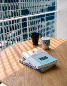 ein Buch auf einem Tisch mit einer Tasse und einer Kaffeetasse in der Unterkunft Blu 395 in Bangkok