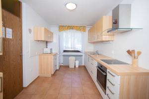 Elle comprend une petite cuisine avec des placards blancs et une fenêtre. dans l'établissement Apartment Melody Bled, à Bled