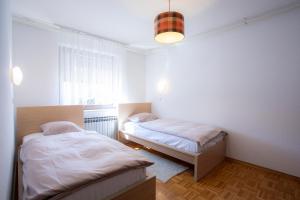 - une chambre avec 2 lits et une fenêtre dans l'établissement Apartment Melody Bled, à Bled