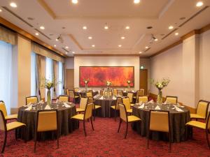 a conference room with tables and chairs and a painting at President Hotel Mito in Mito