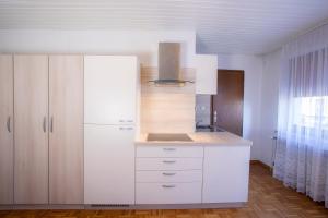 una cocina con armarios blancos y fregadero en Apartment Harmony Bled, en Bled