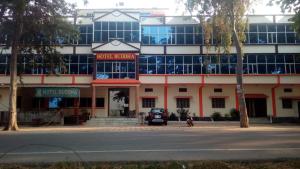 un edificio con un coche aparcado delante de él en HOTEL BUDDHA en Kushinagar