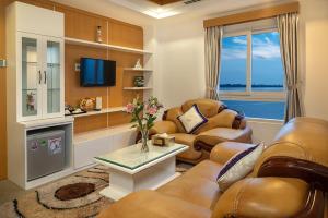 een woonkamer met lederen meubels en een televisie bij Nesta Hotel Can Tho in Can Tho