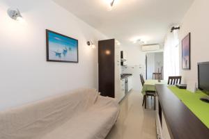 a living room with a couch and a dining room table at Apartments Darko near the sea in Baška