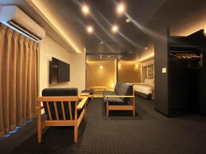 a hotel room with a bed and two chairs at Randor Residential Hotel Fukuoka Annex in Fukuoka