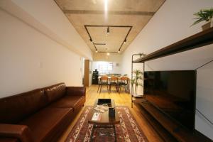 a living room with a couch and a table at goom Hotel Hakata-Higashihie-Ekimae in Fukuoka +30 photos