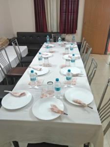 una mesa larga con platos y botellas de agua. en HOTEL BUDDHA, en Kushinagar