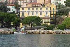 a boat in the water in front of a large building at Hotel Belvedere in Portovenere
