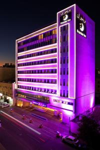 a building with purple lights on the side of it at Premier Inn Doha Airport in Doha