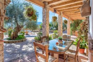 - patio ze szklanym stołem i krzesłami w obiekcie Alojamiento Rural La Pila w mieście Ronda