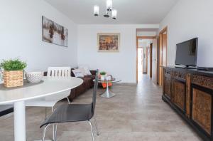 sala de estar con mesa blanca y TV en Formentor Arysal II, en Salou