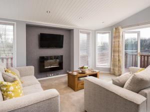 a living room with two chairs and a fireplace at Waternook Lodge in Carnforth