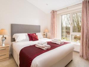 1 dormitorio con 1 cama con toallas en Waternook Lodge en Carnforth