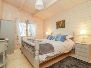 a bedroom with a bed in a room with wooden walls at Gardener's Lodge in York