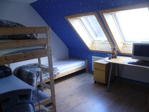 1 dormitorio con litera, escritorio y 2 ventanas en Traumharz, en Sankt Andreasberg