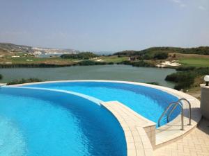 Thracian Cliffs Owners Apartments في كافارنا: مسبح ازرق كبير بجانب جسم ماء