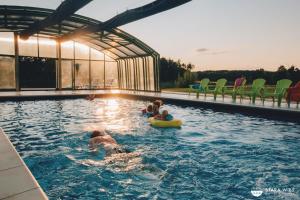 a group of children playing in a swimming pool at Resort Stara Wieś in Załęcze Małe