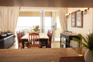 a living room with a table and a dining room at Pinnacle Point Beach & Golf - Penthouse & Villa in Mossel Bay