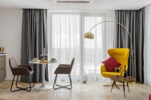 a living room with a yellow chair and a table at Novum By the Sea in Olimp