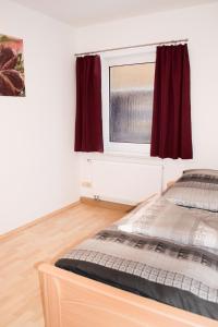 a bedroom with a bed and a window at FeWo Bucker in Lauscha