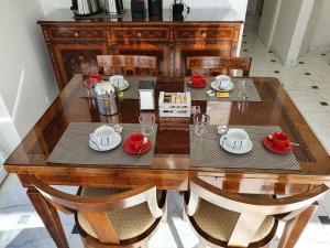 a dining room table with chairs and a wooden table with red accents at Il Parco 2 by Quokka 360 - cosy flat with terrace in Lugano