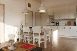 uma cozinha e sala de jantar com mesa e cadeiras em Vakantie met sauna in Zeeland em Sint-Annaland
