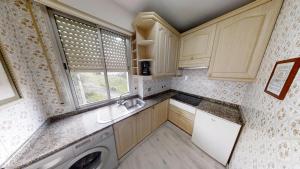 a small kitchen with a washer and dryer at Apartamentos Design Pinemar in Cabañas
