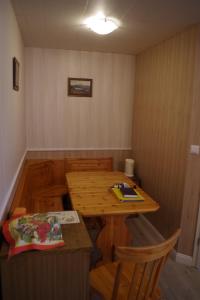 Habitación pequeña con mesa de madera y sillas. en Haus Barnabas im Engel, Gasthaus Engel, en Utzenfeld