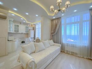 sala de estar con sofá blanco y ventana grande en Апартаменты у моря, Аркадия, en Odessa