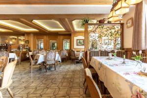 a restaurant with tables and chairs in a room at Hotel-Gasthof Zum Dragoner in Peiting