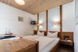 ein Schlafzimmer mit einem großen Bett und einem Fenster in der Unterkunft Hotel-Gasthof Zum Dragoner in Peiting