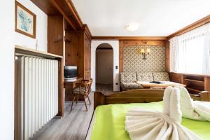 een slaapkamer met een groen bed en een bank bij Hotel-Gasthof Zum Dragoner in Peiting