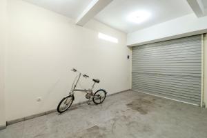 un vélo garé dans une chambre avec une porte de garage dans l'établissement Omah Kemiri 4 Yogyakarta, à Beran-kidul