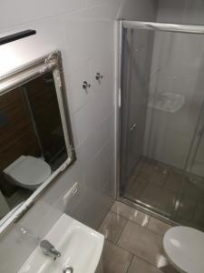 y baño con ducha, lavabo y espejo. en Apartamenty Lawendowy Zakątek 2, en Opole