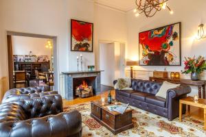 a living room with leather couches and a fireplace at Fletcher Hotel Paleis Stadhouderlijk Hof in Leeuwarden
