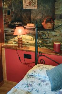 Un dormitorio con una cama y una lámpara en un escritorio. en Esquíos - Apto. El Pajar, en Taramundi