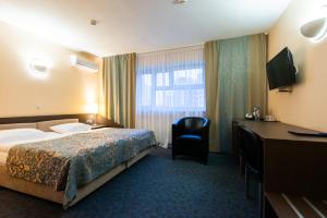 a hotel room with a bed and a desk at IBB Hotel in Minsk