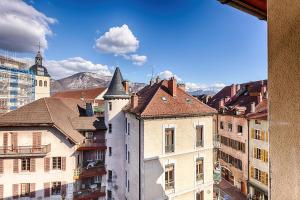 a group of buildings in a city with mountains in the background at appart Filaterie Annecy in Annecy