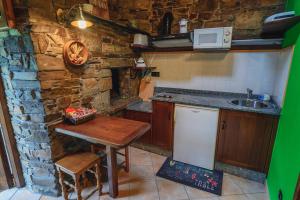 een kleine keuken met een houten tafel en een wastafel bij Esquíos - Apto. Cuarto do forno in Taramundi