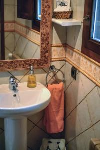 a bathroom with a sink and a mirror at Esquíos - Apto. Cuarto do forno in Taramundi