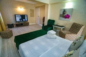 ヴァマ・ヴェケにあるFloare de Irisのベッド1台、薄型テレビが備わるホテルルームです。
