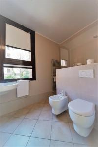 Baño blanco con aseo y lavamanos en BED in BO Saragozza en Bolonia