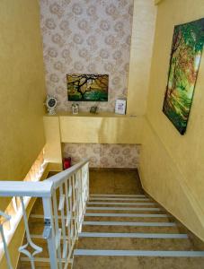 un escalier dans une maison ornée d'une peinture murale dans l'établissement Floare de Iris, à Vama Veche