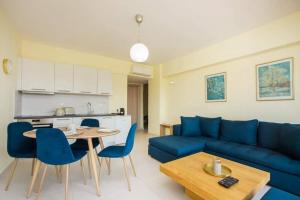 a living room with a blue couch and a table at Eden Almond Tree - Luxurious Apartment with Sea View in Rhodes Town