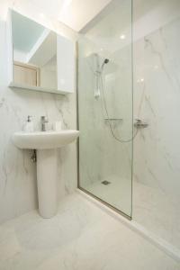 a white bathroom with a sink and a shower at Eden Almond Tree - Luxurious Apartment with Sea View in Rhodes Town