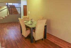 a dining room with a glass table and chairs at Surya Kiran Miramar in Panaji